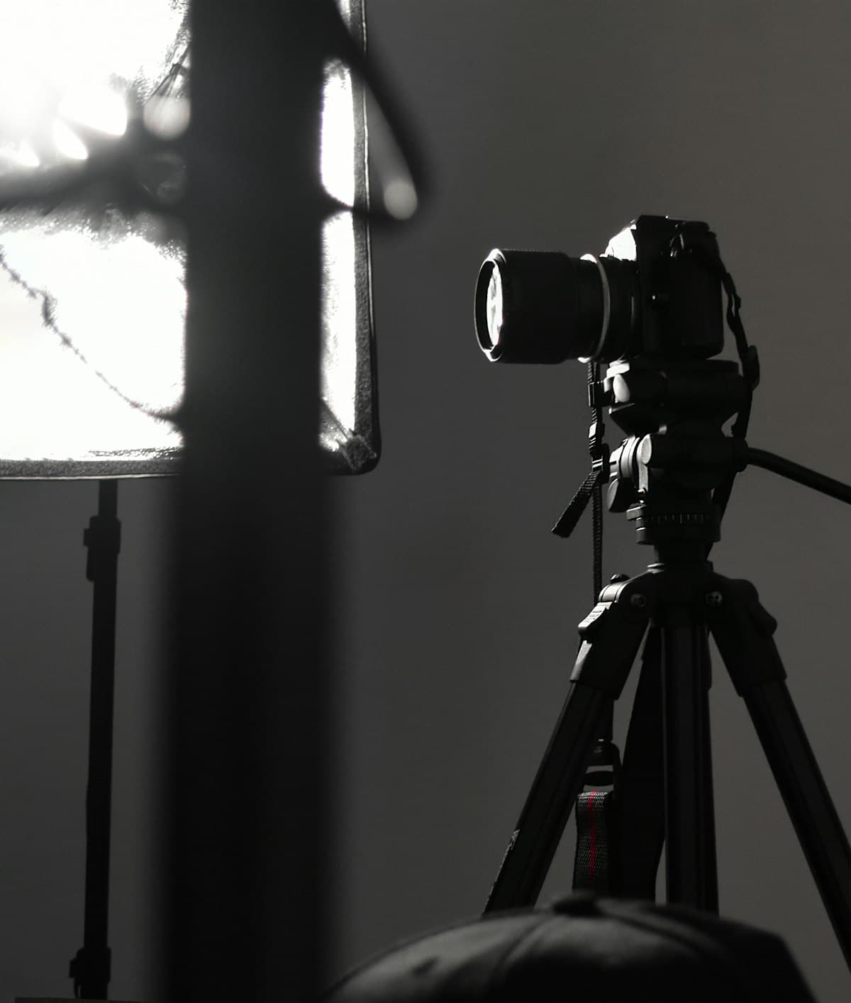 A camera mounted on a tripod facing a lit studio wall