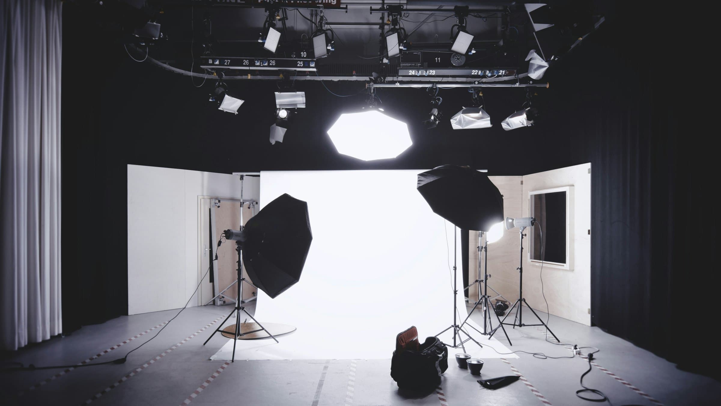 Studio lights and a seamless backdrop in a darkened photography studio
